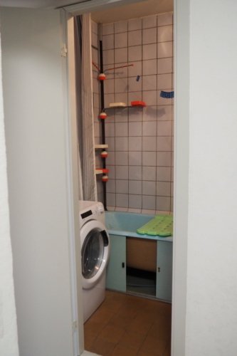 Ванная до ремонта: на полу и стенах старая плитка, чугунная крашенная ванна и облезлый потолок