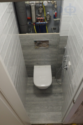 Отремонтированный туалет с подвесным унитазом и гигиеническим душем