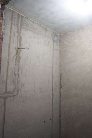 Подготовленная к укладке плитки ванная комната с очищенными и выровнеными стенами, подвесным потолком