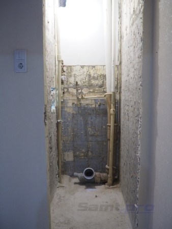 Вид туалета после демонтажа унитаза, шкафчика, труб и старой плитки