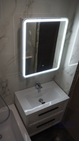 Шкаф зеркало с подсветкой над умывальником в отремонтированной ванной